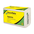 A package of Snowflake Supreme Quality Woodshavings, featuring a white block of woodshavings wrapped in paper with a bright yellow and green label.